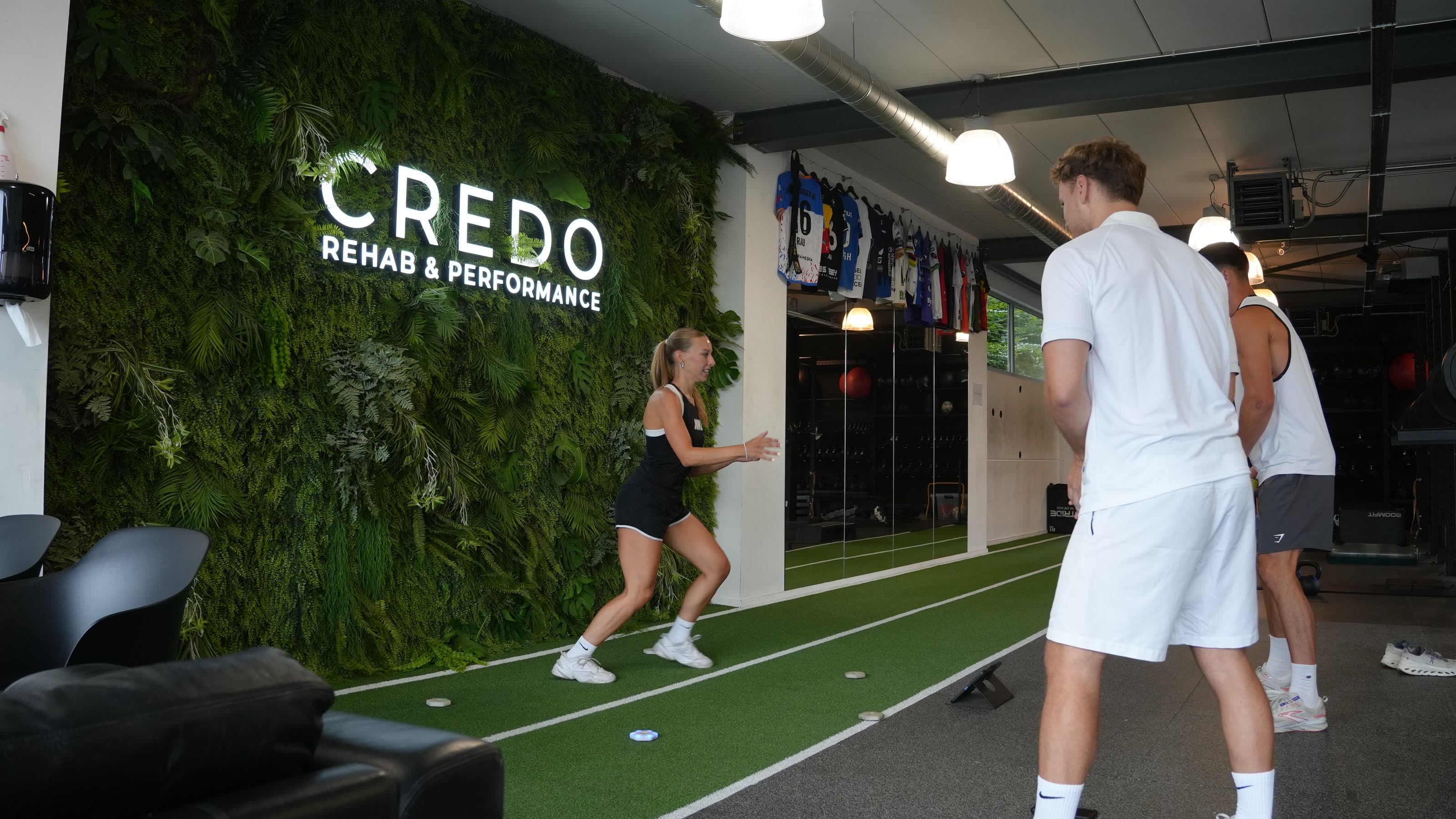 De indoorpiste langs de mosmuur, met coach en atlete aan het werk.