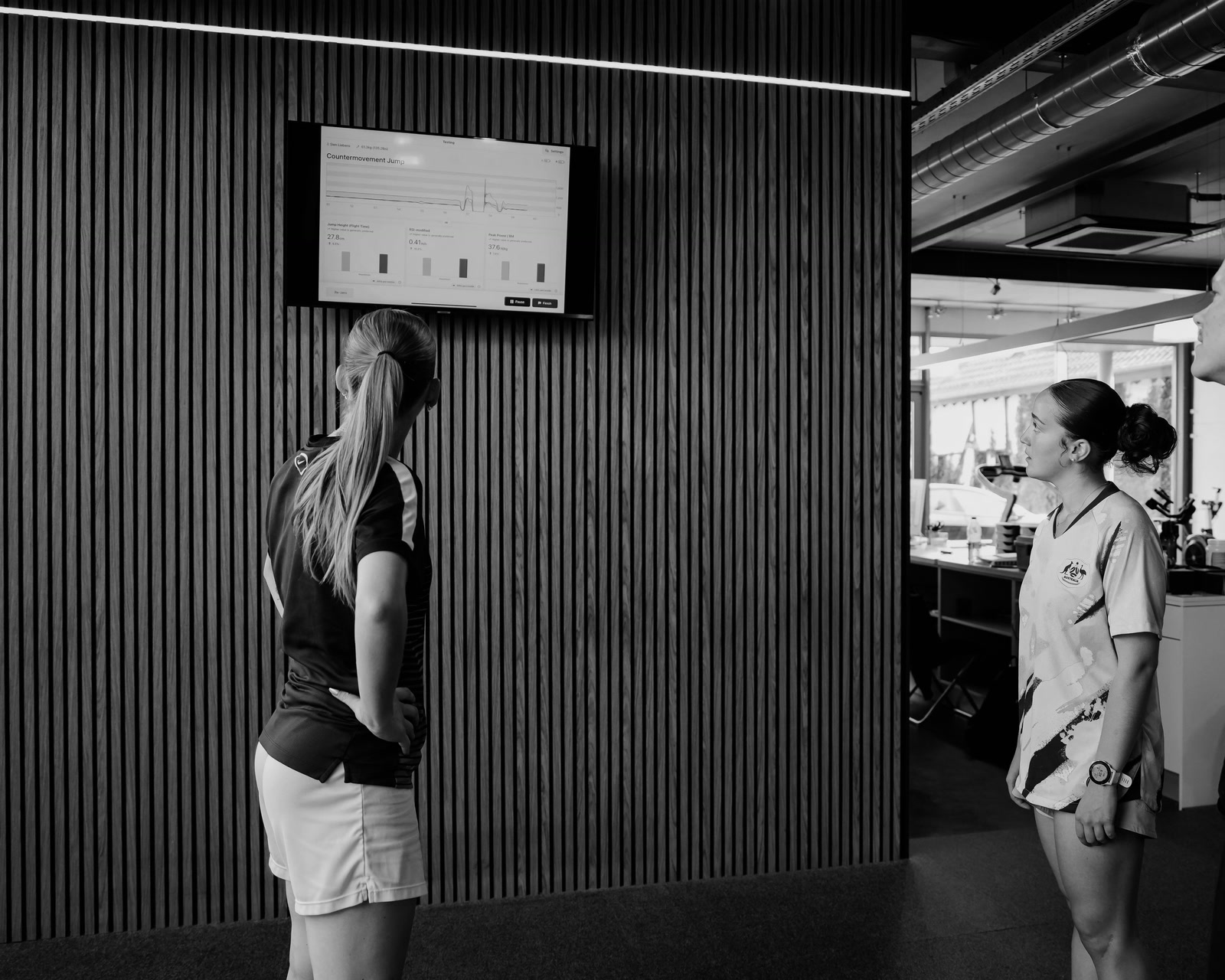 Atlete en coach bij het scherm met de testresultaten.