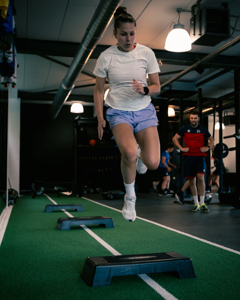 Atlete loopt over de steps op de mat.